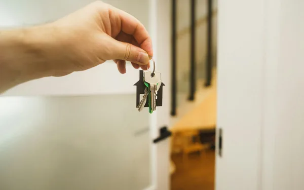 A hand holding keys to a family home, representing a conditional lifetime gift under Ruqba and Umra