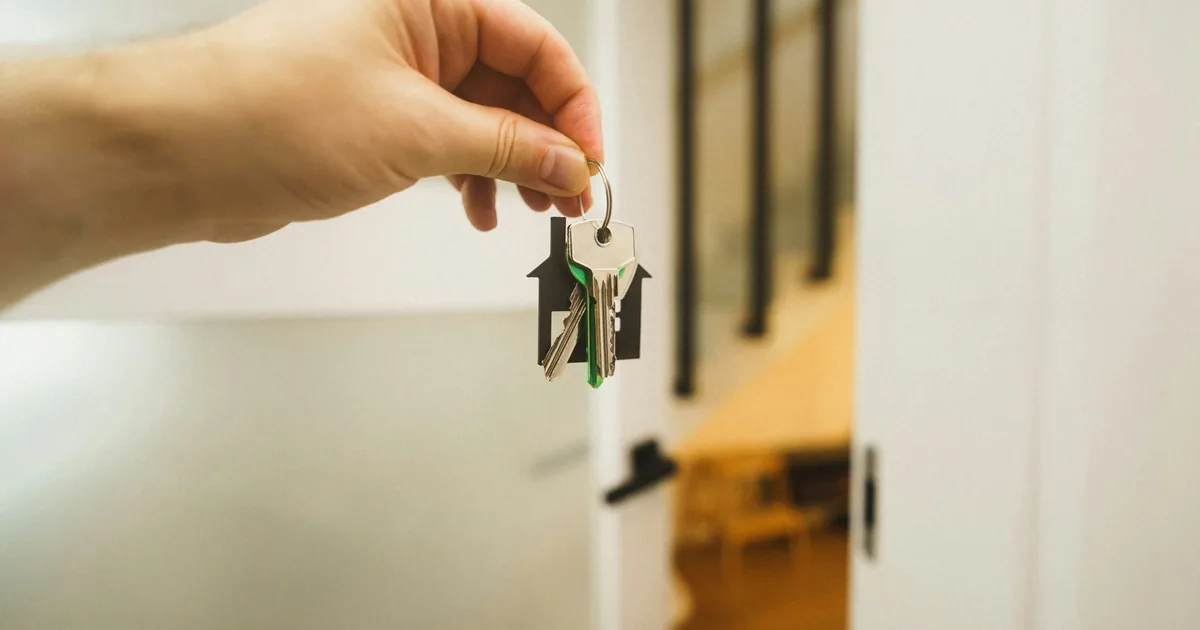 A hand holding keys to a family home, representing a conditional lifetime gift under Ruqba and Umra