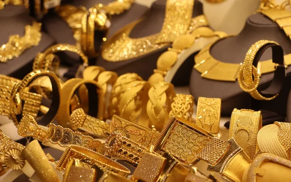 A display case of gold bracelets and necklaces, representing the gold-weight basis for calculating Mahr