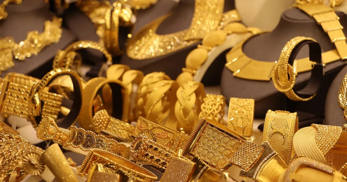 A display case of gold bracelets and necklaces, representing the gold-weight basis for calculating Mahr