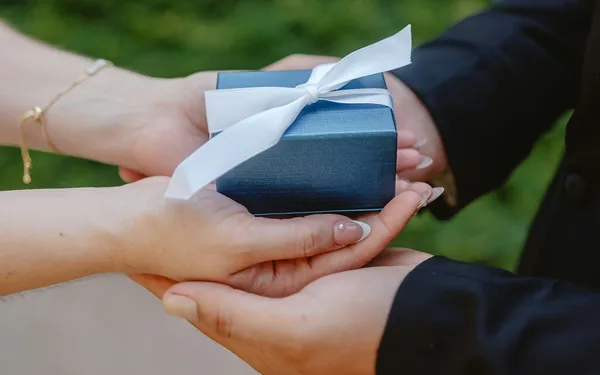 Hands exchanging a wrapped gift, representing Hibah, the Islamic lifetime gift